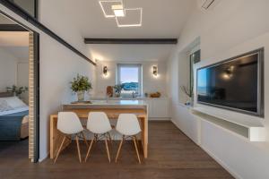 a kitchen and dining room with a television and a table and chairs at Casa Emily in Portovenere