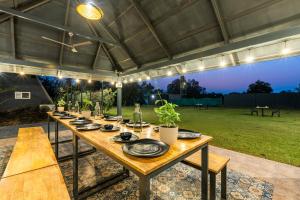 a long wooden table with plates on it under a tent at Alaya stays Inara Retreat 1-Cottage with a Mezzanine Loft, Shared Pool, and Garden in Bangalore