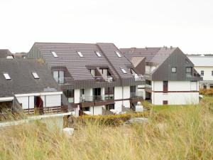 eine Reihe von Häusern an der Seite eines Strandes in der Unterkunft Wenningstedt Beach Apartment in Wenningstedt-Braderup