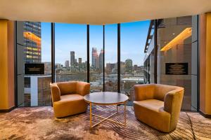 two chairs and a table in a room with windows at Riu Plaza London The Westminster in London