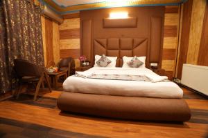 a bedroom with a large bed and a table at Hotel Park Plaza Srinagar in Srinagar