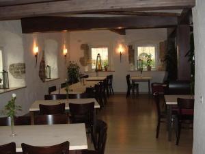 a dining room with tables and chairs and windows at Gasthaus Rose in Niedernhall