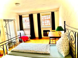 a bedroom with a bed and a table and windows at Gasthaus Rose in Niedernhall