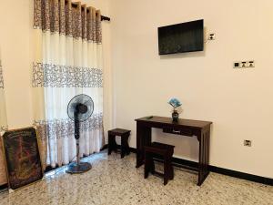 a room with a fan and a desk and a television at Yala Dream Wild Resort in Tissamaharama