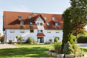a large white house with a red roof at Hotel & Tagungszentrum Blaubeuren - Hessenhöfe in Blaubeuren