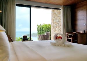 a bedroom with a bed with a view of the ocean at Cape Azure Resort Samui by Thalsea in Plai Laem