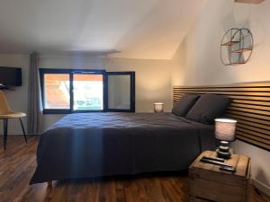a bedroom with a large bed and a window at Ain’Time in Biziat