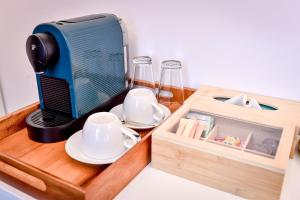 a table with a coffee maker and cups and a box at Casa Baritiu - budget in Braşov
