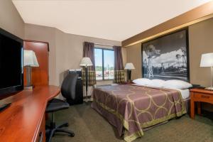 a hotel room with a bed and a desk and a television at Super 8 by Wyndham Jasper in Jasper +37 photos