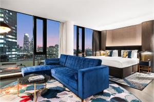 a hotel room with a bed and a blue couch at Riu Plaza London The Westminster in London +102 photos