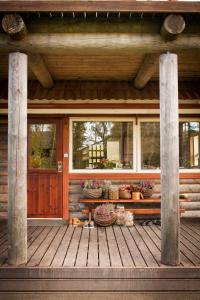 a porch of a log cabin with a bench and windows at Lammasmäe Puhkekeskus in Linnuse