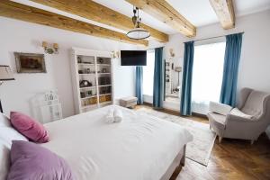 a bedroom with a large white bed and a chair at Casa Baritiu - budget in Braşov
