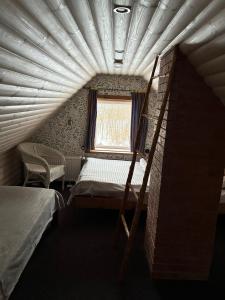 a small room with a bed and a window at Lammasmäe Puhkekeskus in Linnuse