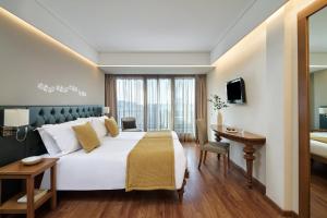 een hotelkamer met een groot bed en een bureau bij Titania Hotel in Athene +125 foto's