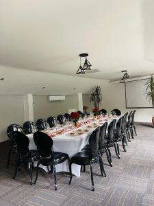 a long table in a room with black chairs at Pari Guest House in Middelburg