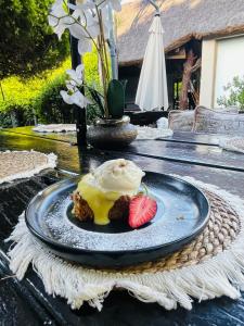 a dessert with ice cream and a strawberry on a plate at Pari Guest House in Middelburg