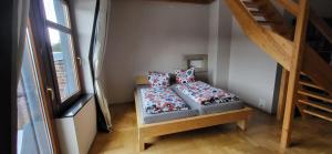 a room with a bed with pillows and a staircase at Appartment Paula in Heinsdorfergrund