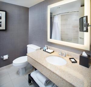 uma casa de banho com um lavatório, um WC e um espelho. em Crowne Plaza Annapolis, an IHG Hotel em Annapolis