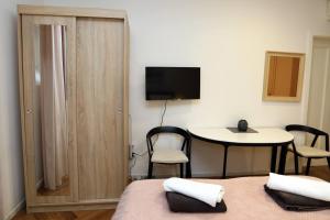 a room with two beds and a table and a television at DJ Pula Studio - City Center in Pula