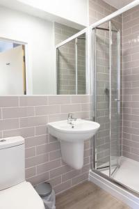 a white bathroom with a sink and a shower at Spa Court in Cheltenham