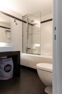 a bathroom with a toilet and a sink and a tub at Esplanada Studios in Genk +13 photos