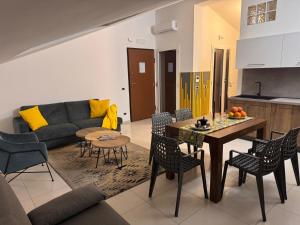 a living room with a couch and a table and chairs at Bella Tao Apart in Taormina