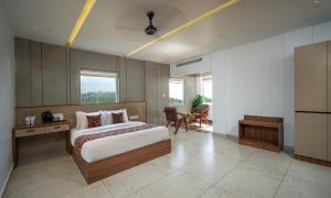 a bedroom with a bed and a table and chairs at Boulevard Premium Luxury Hotel in Munnar