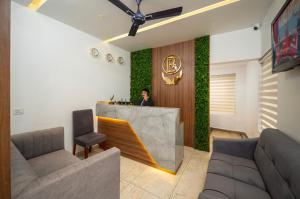 a person standing in a lobby with a wall of ivy at Boulevard Premium Luxury Hotel in Munnar