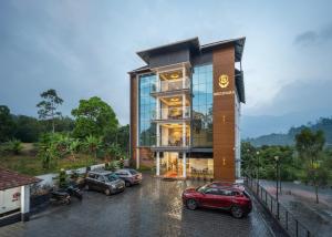a building with cars parked in a parking lot at Boulevard Premium Luxury Hotel in Munnar