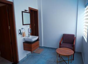 a bathroom with a sink and a chair at Boulevard Premium Luxury Hotel in Munnar +44 photos