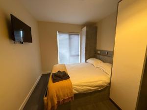 a bedroom with a bed with a hat on it at Magna House in Egham