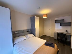 a bedroom with a large bed and a desk at Magna House in Egham +60 photos