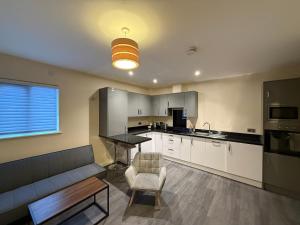 a kitchen with a couch and a table in a room at Magna House in Egham