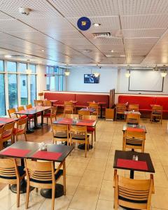 a dining room with tables and chairs and a screen at Delta Continental Hotel and Suite, Lagos in Lagos
