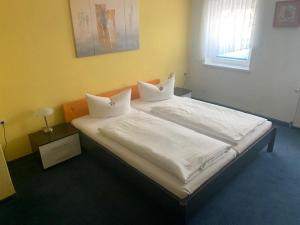 a bedroom with a bed with white sheets and pillows at Hotel Schwarzes Ross Siebenlehn in Siebenlehn +53 photos