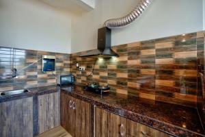 a kitchen with a counter with a sink and a stove at Baga Riverview 2BHK Mayonna Apartment in Baga +12 photos
