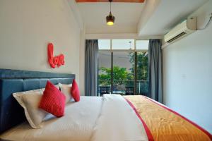 a bedroom with a large bed with red pillows at Baga Riverview 2BHK Mayonna Apartment in Baga