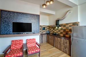 a kitchen with two red chairs and a refrigerator at Baga Riverview 2BHK Mayonna Apartment in Baga