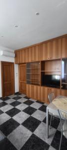 a kitchen with wooden cabinets and a checkered floor at Silvia Butterfly Flat in Genoa