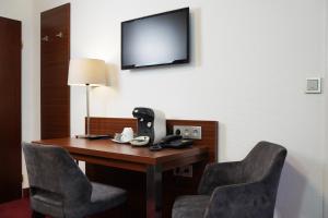 a room with a desk with two chairs and a telephone at Haus Sparkuhl Hotel Garni in Hannover