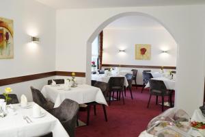 a restaurant with white tables and chairs and an archway at Haus Sparkuhl Hotel Garni in Hannover