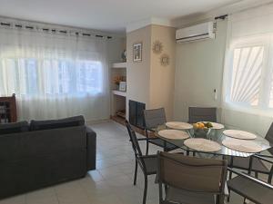 a living room with tables and chairs and a couch at Casa del Llimoner in L'Escala