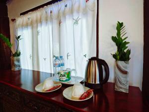a wooden table with two plates of food on it at Huen Tip Viman Chiangmai in Ban Nong Ho