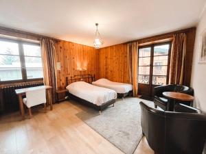 a bedroom with two beds and a desk and chairs at Hotel Le Genepy in Tignes