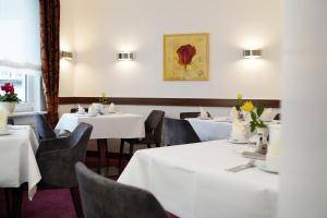 a dining room with white tables and chairs at Haus Sparkuhl Hotel Garni in Hannover +24 photos