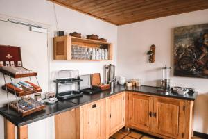 a kitchen with a black counter top and wooden cabinets at Hotel Le Genepy in Tignes