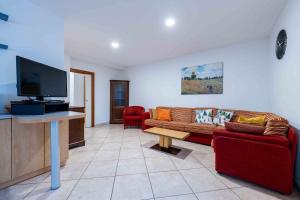 a living room with a couch and a flat screen tv at Cesa Primula in Canazei