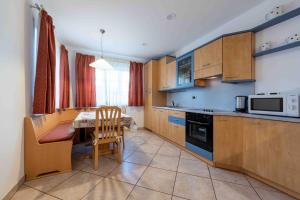 a kitchen with a table and a chair and a microwave at Cesa Primula in Canazei