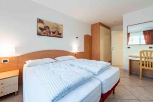 a bedroom with a bed and a table and a desk at Cesa Primula in Canazei