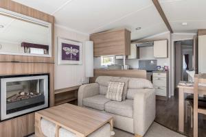 a living room with a chair and a fireplace in a caravan at Hotel du Van - Rockley Park Caravan, Activities On-site in Poole